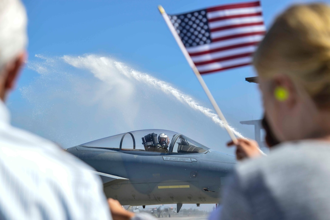 U.S. Air Force 1st Lt. Jonathan Pavan, 194th Fighter Squadron F-15 pilot, waves to Airmen and their families at the Fresno Air National Guard Base as he taxis in returning from a deployment Oct. 2, 2016. A total of nine F-15s returned home after a deployment in Europe as part of a Theater Security Package in support of Operation Atlantic Resolve. (U.S. Air National Guard photo by Senior Airman Klynne Pearl Serrano)