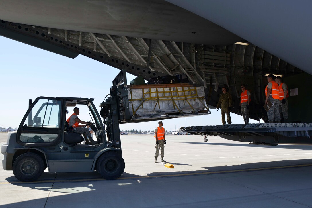 Airmen assigned to the 144th Logistics Readiness Squadron, Fresno Air National Guard, help Airmen from the 3rd Airlift Squadron out of Dover Air Force Base, Delaware, unload cargo from a C-17 at the Fresno ANG Base Oct. 1, 2016. The cargo consisted of supplies and tools used by the 144th Fighter Wing during a deployment to Europe as part of a Theater Security Package in support of Operation Atlantic Resolve. (U.S. Air National Guard photo by Senior Airman Klynne Pearl Serrano)