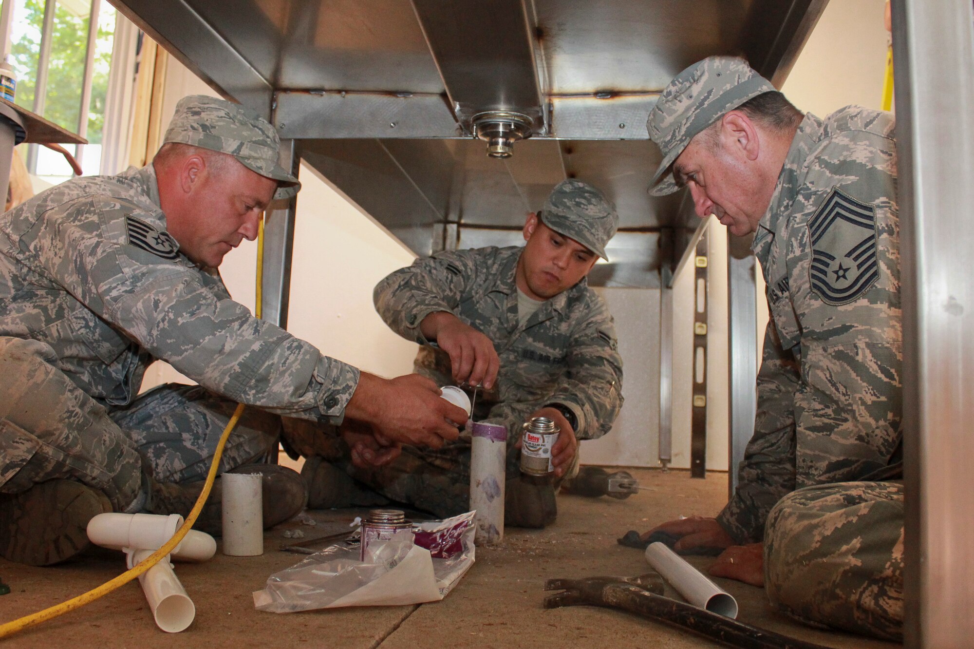 Airmen with the Civil Engineer Squadron, 128th Air Refueling Wing, Wisconsin Air National Guard, work to assemble a drain system on the fish-cleaning station Sept. 23, 2016. Other features of the station include a push-button, handicap-accessible front door, a stainless-steel fish-cleaning station with hanging hoses and electrical outlets, and other equipment. (U.S. Air Force photo by Senior Master Sgt. Kyle Fugar/Released)