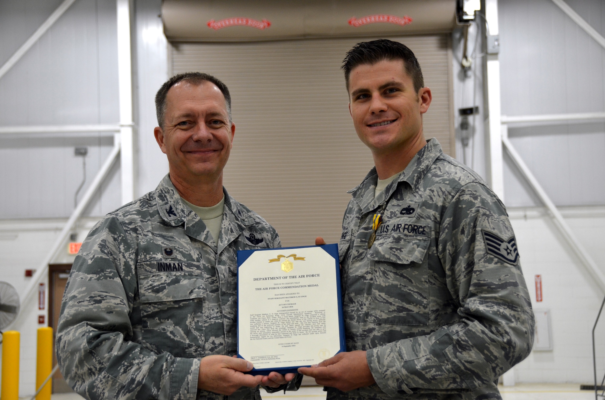 Col. Randall Inman, 161 MXG commander, presents Staff Sgt. Matthew St. Onge, 161st Maintenance Squadron, crew chief, with a certificate to accompany his Air Force Commendation Medals Oct., 2016, 161st Air Refueling Wing, Phoenix. The Airmen were awarded the medal for rescuing a woman after a head-on car accident. (U.S. Air National Guard photo/Tech. Sgt. Michael Matkin)