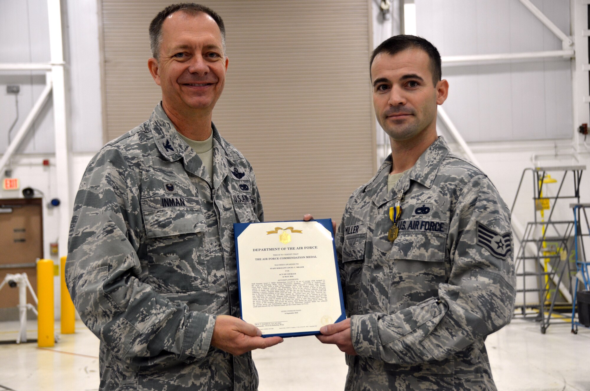 Col. Randall Inman, 161 MXG commander, presents Staff Sgt. Ancel Miller, 161st Maintenance Squadron, electrical environmental specialist, with a certificate to accompany his Air Force Commendation Medals Oct., 2016, 161st Air Refueling Wing, Phoenix. The Airmen were awarded the medal for rescuing a woman after a head-on car accident. (U.S. Air National Guard photo/Tech. Sgt. Michael Matkin)