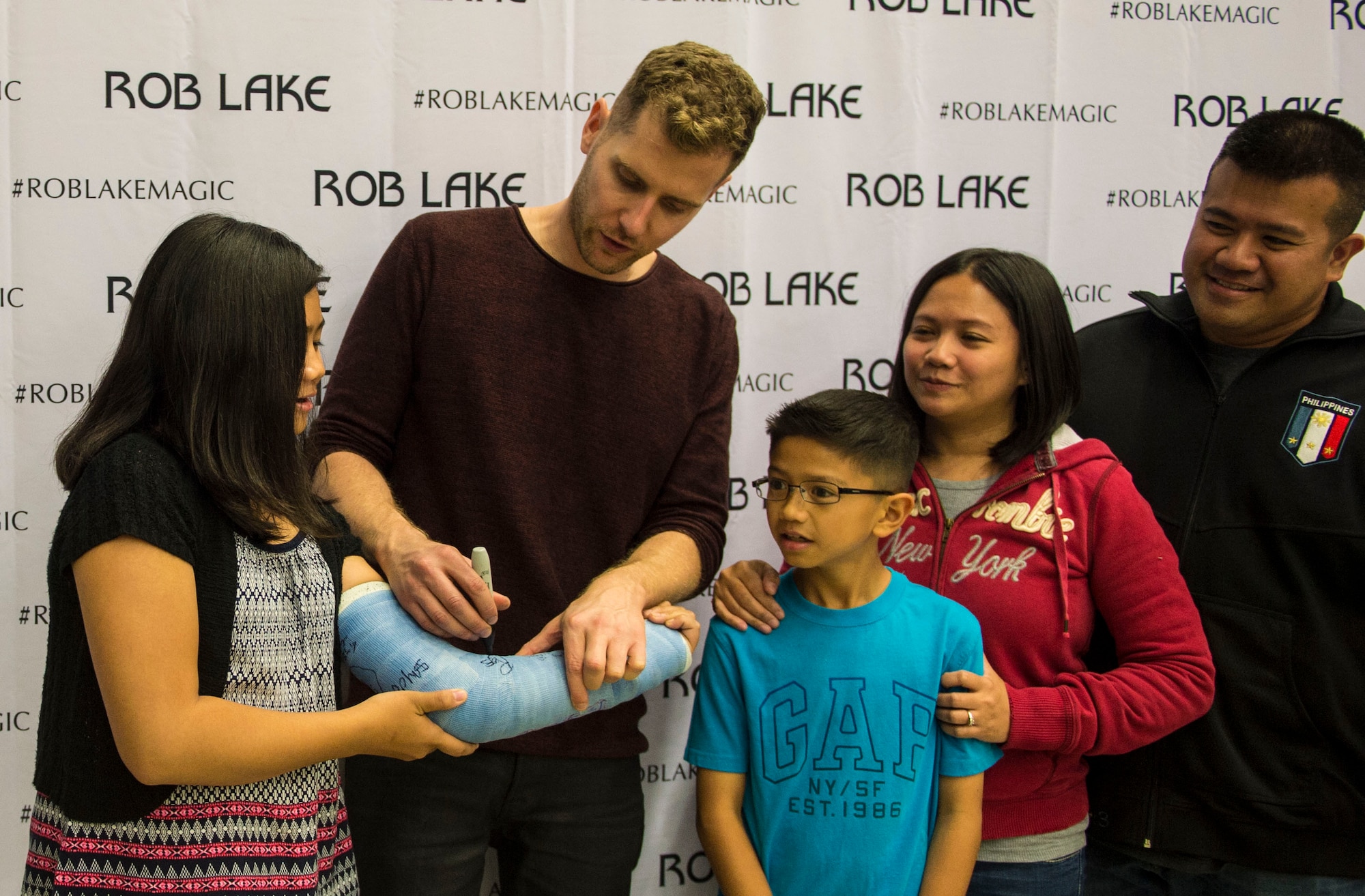 Rob Lake, a magician, signs a girl’s cast after a free magic show at Ramstein Air Base, Germany, Sept. 28, 2016. Lake and his team coordinate with Armed Forces Entertainment to perform shows for U.S. military members serving overseas. (U.S. Air Force photo/ Airman 1st Class Joshua Magbanua)