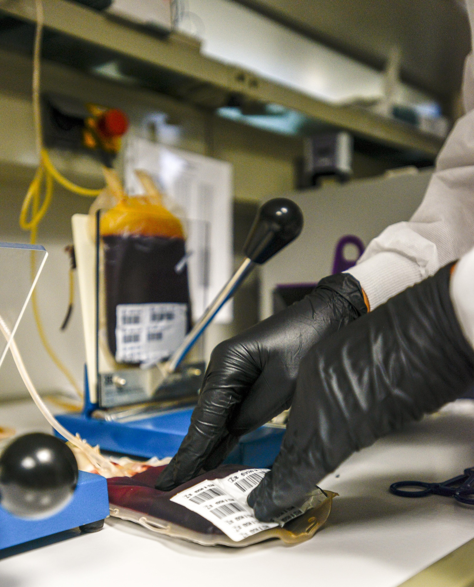 U.S. Air Force Staff Sgt. Joseph-Luis Kilgo, 86th Medical Squadron NCO in charge of training, pats a bag of blood at Landstuhl Regional Medical Center, Sept. 22, 2016. After the blood and plasma have been manually separated, clumped protein must be mixed back into the blood to ensure it is distributed throughout the entire unit. (U.S. Air Force photo by Staff Sgt. Timothy Moore)