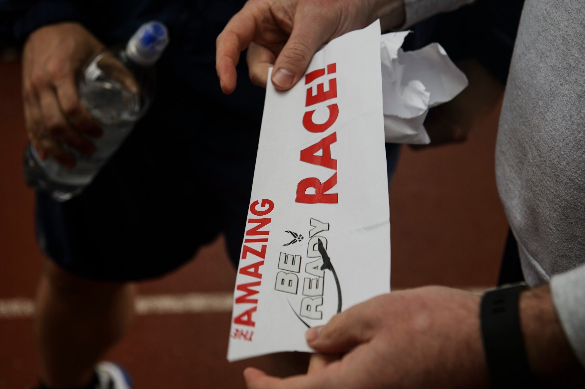An Airman gets ready to read his team's first clue during an Amazing Race 5k event on Spangdahlem Air Base, Germany, Sept. 30, 2016. Airmen answered questions and solved puzzles at each check point during the event based on National Preparedness Month. (U.S. Air Force photo by Staff Sgt. Jonathan Snyder)                     