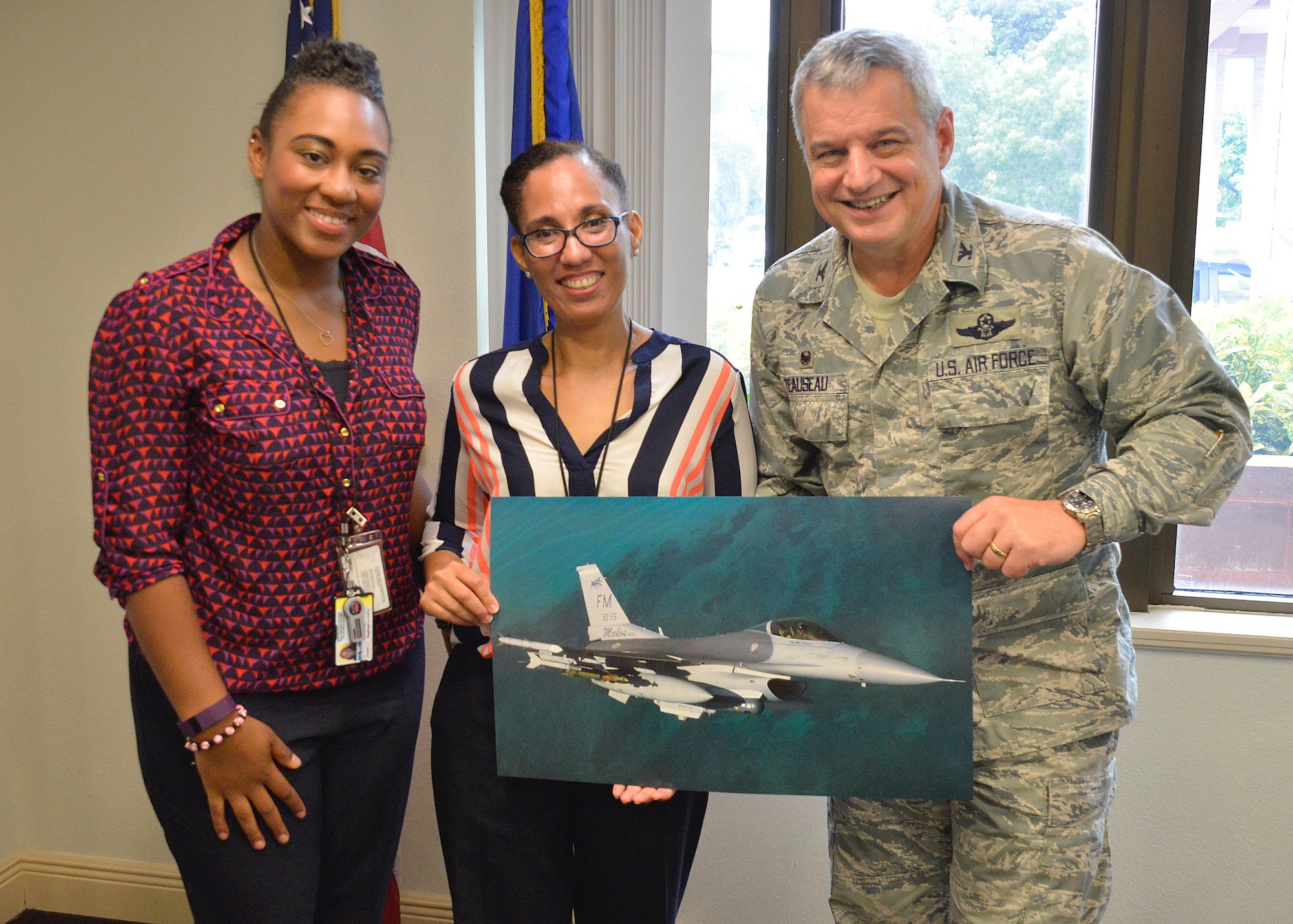 Col. Alan Teauseau, 482nd Mission Support Group commander, presents a Fighter Falcon image to Brittney Odom and Carmen Roman visitors from The Center for Disease Control and Prevention Miami Quarantine station at Homestead Air Reserve Base, Fla., Sept. 26. The station’s jurisdiction includes the preclearance ports in Florida, Mississippi, Alabama, the Bahamas and Aruba. (U.S. Air Force photo by Staff Sgt. Desiree W. Moye)