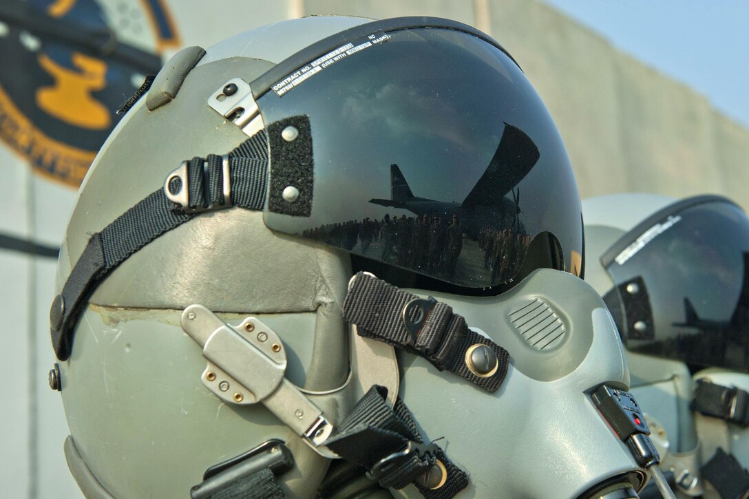 A reflection of airmen is displayed on the visor of a pilot’s helmet during a remembrance ceremony at Bagram Airfield, Afghanistan, Oct. 2, 2016. Air Force photo by Capt. Korey Fratini