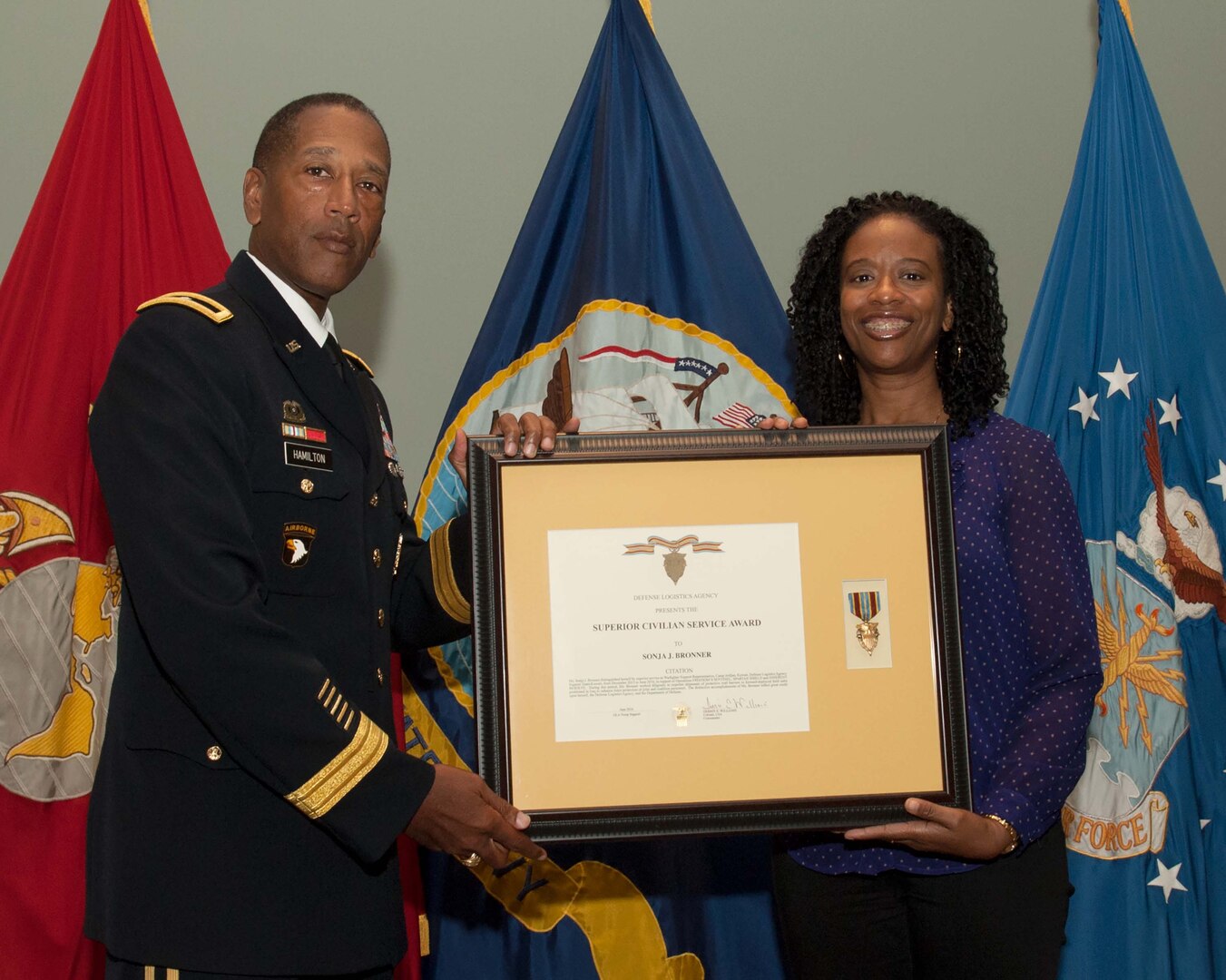DLA Troop Support Commander Army Brig. Gen. Charles Hamilton, left, presents tailored vendor logistics specialist Sonja Bronner, right, with a Superior Civilian Service Award during a Quarterly Awards ceremony Sept. 28. Bronner earned the award for serving as a warfighter support representative for the DLA Support Team Kuwait in support of Operations Freedom Sentinel, Spartan Shield and Inherent Resolve.