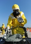 An Emergency Management Support Team (EMST) member simulates checking alpha radiation levels during training at Whiteman Air Force Base, Mo., Sept. 21, 2016. The EMST use ADM-300 multi-functional survey instruments to detect, measure and digitally display alpha, beta, gamma, and x-rays. (U.S. Air Force photo by Senior Airman Danielle Quilla)