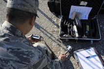 U.S. Air Force Senior Airman Emerson Malabuyoc, a bioenvironmental engineering technician with the 509th Medical Operation Squadron, simulates checking for beta radiation on the ground during training at Whiteman Air Force Base, Mo., Sept. 21, 2016. The training tested the emergency responders’ ability to handle a possible contamination incident. (U.S. Air Force photo by Senior Airman Danielle Quilla)