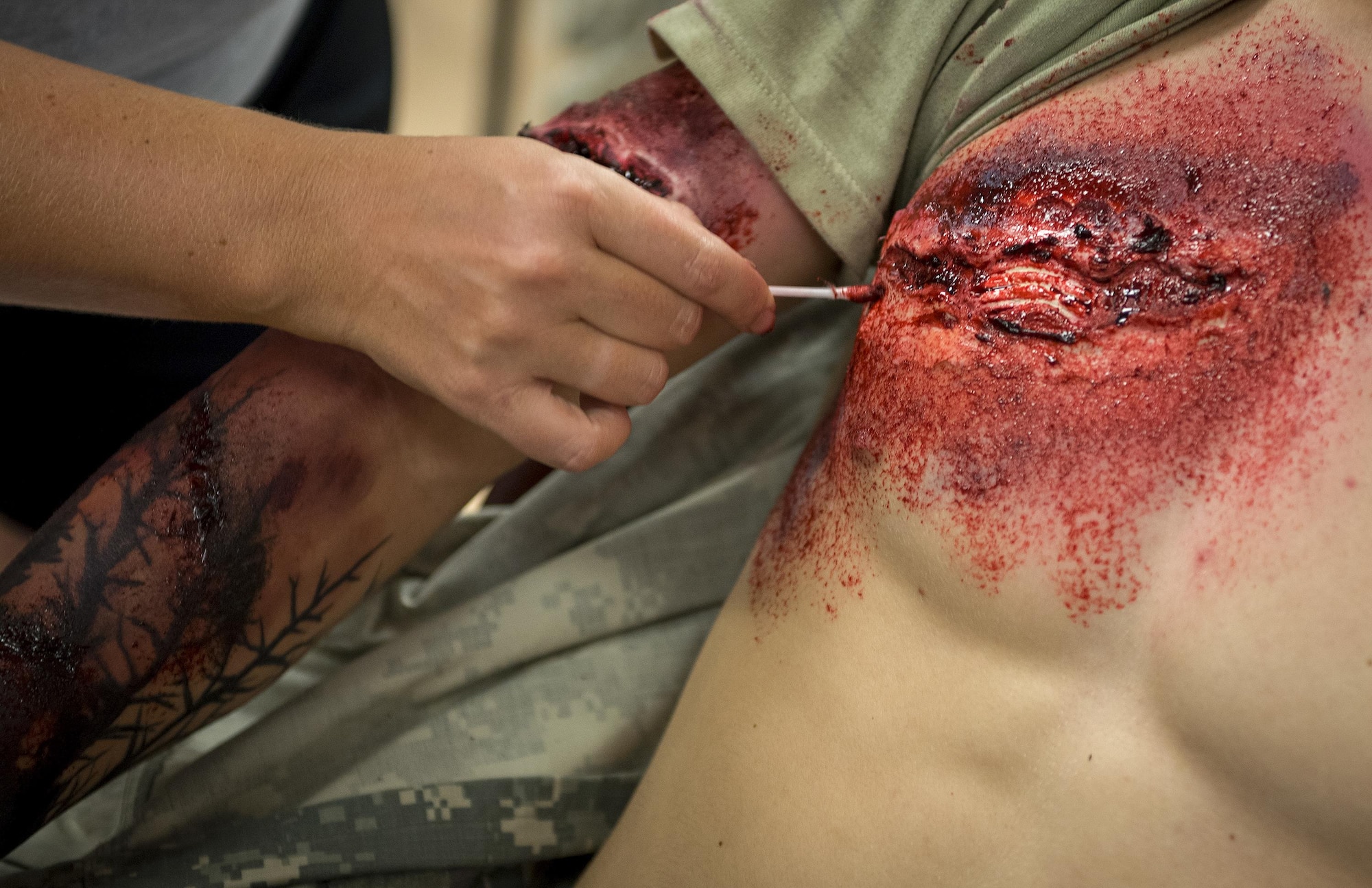 A member of the 96th Medical Group moulage team adds some blood to a simulated wound on a 6th Ranger Training Battalion Soldier prior to a large-scale exercise Sept. 28 at Eglin Air Force Base, Fla.  The team made up cuts, breaks and lacerations for more than 12 Soldiers and civilians.  (U.S. Air Force photo/Samuel King Jr.)