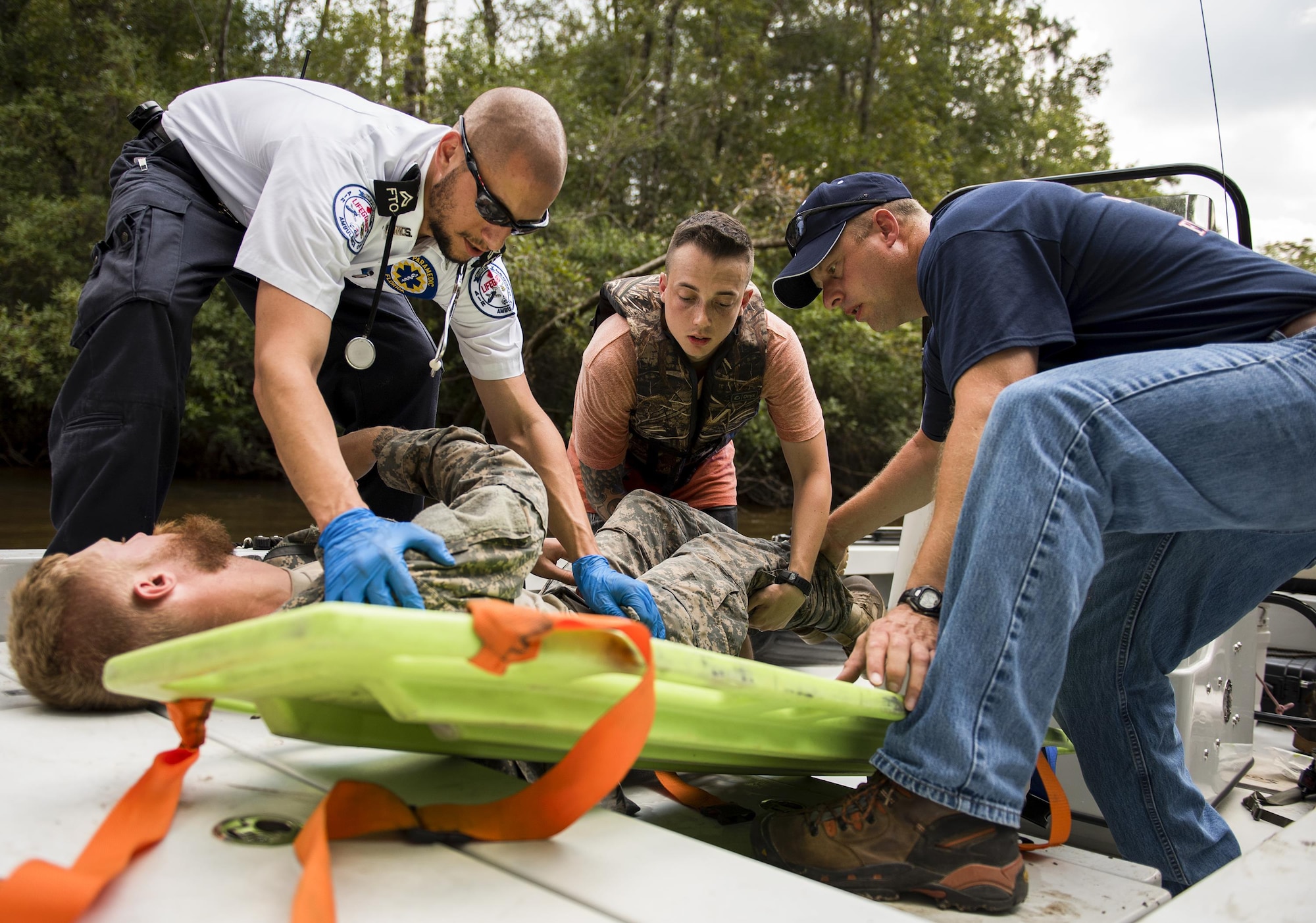Local emergency technicians move a simulated victim onto a back-board for transportation during a mass casualty exercise Sept. 28 at Eglin Air Force Base, Fla.  Three groups of Soldiers in zodiac boats encountered a simulated civilian and Army boat crash.  The Soldiers acted as first responders to triage the victims, coordinate to receive help and get the wounded to local emergency technicians.  (U.S. Air Force photo/Samuel King Jr.)