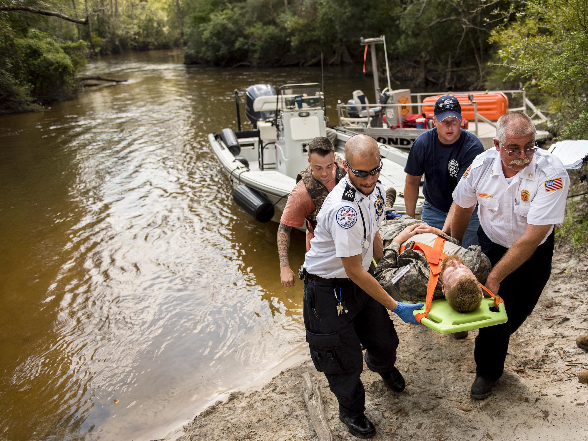 Local emergency technicians transport a simulated victim during a mass casualty exercise Sept. 28 at Eglin Air Force Base, Fla.  Three groups of Soldiers in zodiac boats encountered a simulated civilian and Army boat crash.  The Soldiers acted as first responders to triage the victims, coordinate to receive help and get the wounded to local emergency technicians.  (U.S. Air Force photo/Samuel King Jr.)