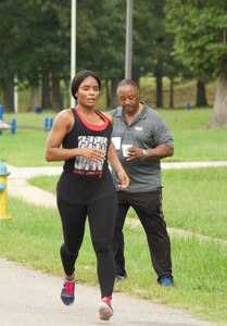 RICHMOND, Va. - Staff Sgt. Son-Joi Brantley, executive administrative non-commissioned officer at the 80th Training Command (TASS), stays focused as she completes her first lap of the Suicide Prevention Awareness 5K Fun Run/Walk at the Defense Supply Center held here on Sep. 28, 2016. Suicide Prevention Program Manager for the 80th TC Dr. Alvin Moore stands in the background with cups of water to hand out to participants. The 80th TC held the event for all Department of Defense employees and their families. (Photo by Maj. Addie Randolph, 80th Training Command (TASS) Public Affairs)