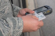 An Airman from the 5th Security Forces Squadron checks an ID card at Minot Air Force Base, N.D., Sept. 30, 2016. Entry controllers check to verify a person’s access to a military installation through the Defense Biometrics Identification System. (U.S. Air Force photo/Airman 1st Class Jessica Weissman)