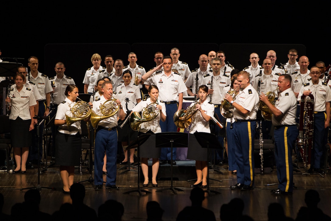 Army Staff Sgt. Selena Maytum (left), U.S. Army Field Band, plays in the horn section playing the National Anthem at a concert.
