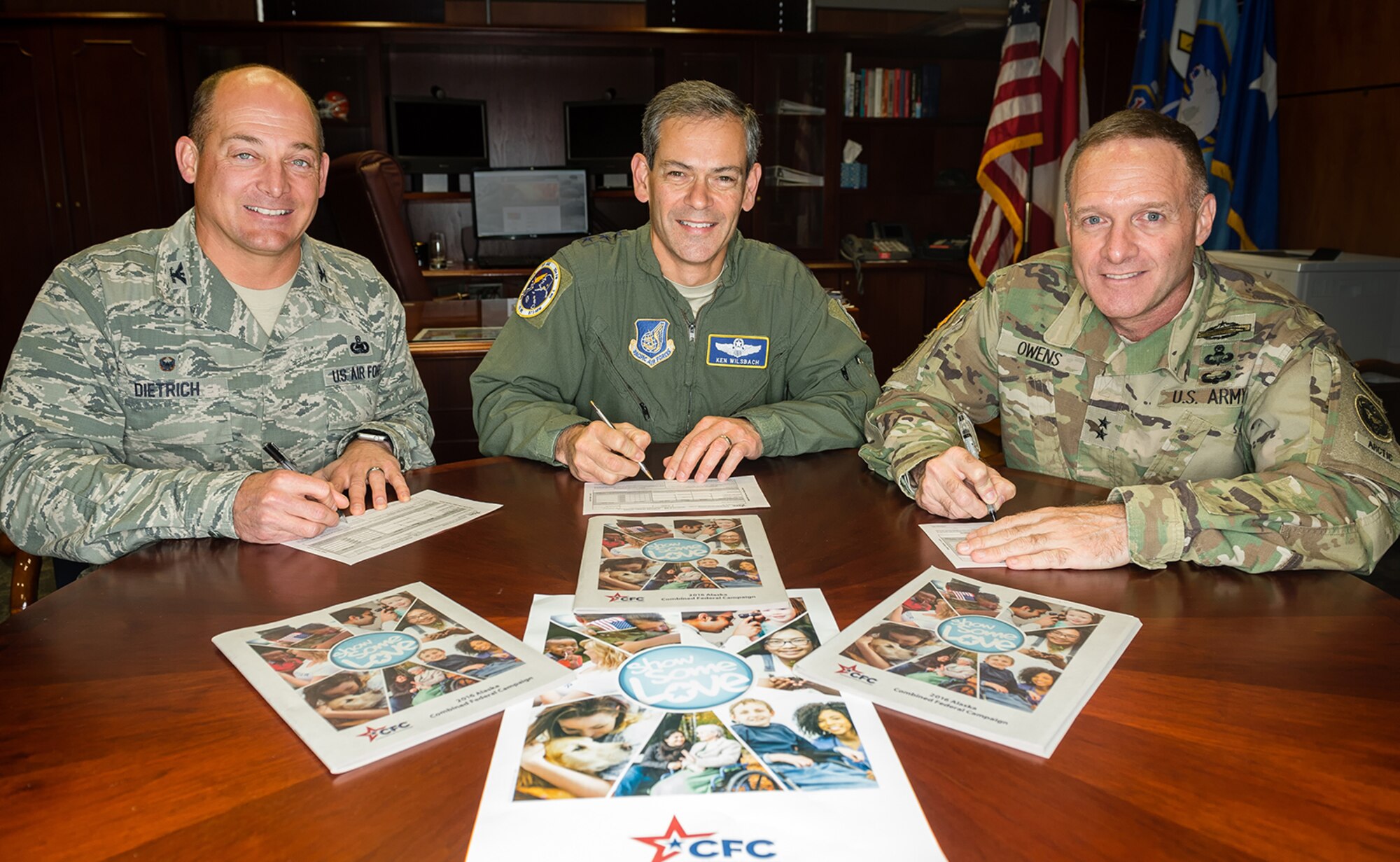 Air Force Col. George “Dutch” Dietrich, commander of Joint Base Elmendorf-Richardson and the 673d Air Base Wing, JBER, Alaska, left, Air Force Lt. Gen. Kenneth S. Wilsbach, commander of Alaskan North American Aerospace Defense Command Region, North American Aerospace Defense Command; Commander, Alaskan Command, U.S. Northern Command; Commander, Eleventh Air Force, Pacific Air Forces, JBER, Alaska, and Army Major Gen. Bryan Owens, commander of U.S. Army Alaska, make donations to the Combined Federal Campaign, Thursday, Sept. 22, 2016, at JBER. Since the CFC was established in 1961, it has provided opportunities for federal employees to give to charities of their choice. 