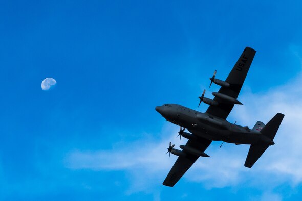 A modified C-130 Hercules banks in front of the moon above the Saylor Creek Training Range, Idaho, Sept. 17, 2016. The aircraft is specifically outfitted to spray hundreds of acres of land with herbicides and water. (U.S. Air Force photo by Senior Airman Connor J. Marth/Released)