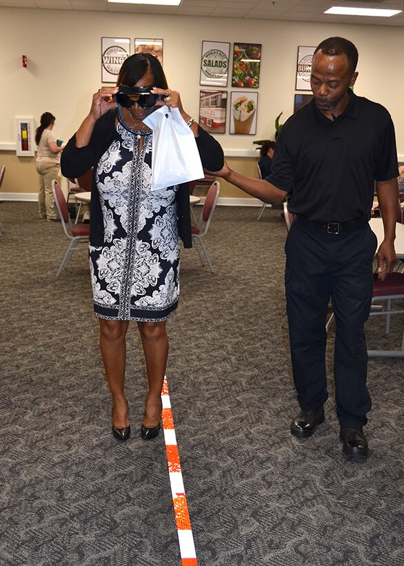 Defense Logistics Agency Installation Support at Richmond, Virginia Police Officer Clarence Jones helps an unidentified employee use the Fatal Vision goggles to experience the effects of driving under the influence during a National Preparedness Fair at Defense Supply Center Sept. 28, 2016. (Photo by Jackie Roberts)