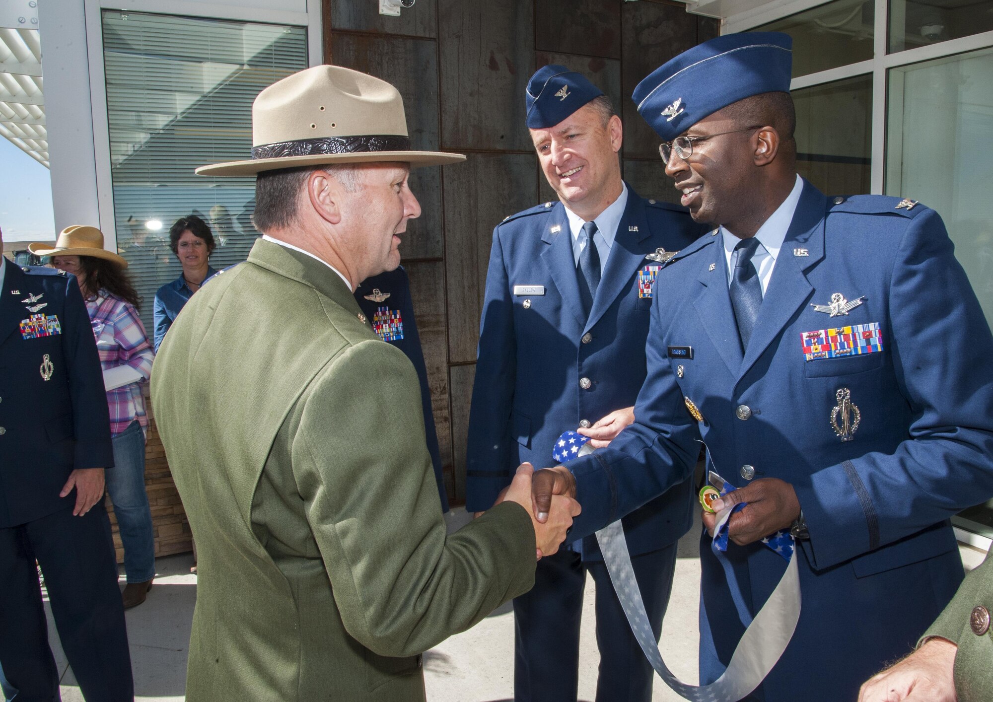 Col. Kelvin Townsend, 91st Missile Wing vice commander, and Col. David Ballew, 5th Bomb Wing vice commander, receive a coin from a National Park Service member at the Minuteman Missile National Historic Site, Philip, S.D., Sept 24, 2016. Townsend and Ballew, along with other Air Force leadership, were invited to attend the grand opening of the site’s visitor center. (U.S. Air Force photo/Airman 1st Class Christian Sullivan)