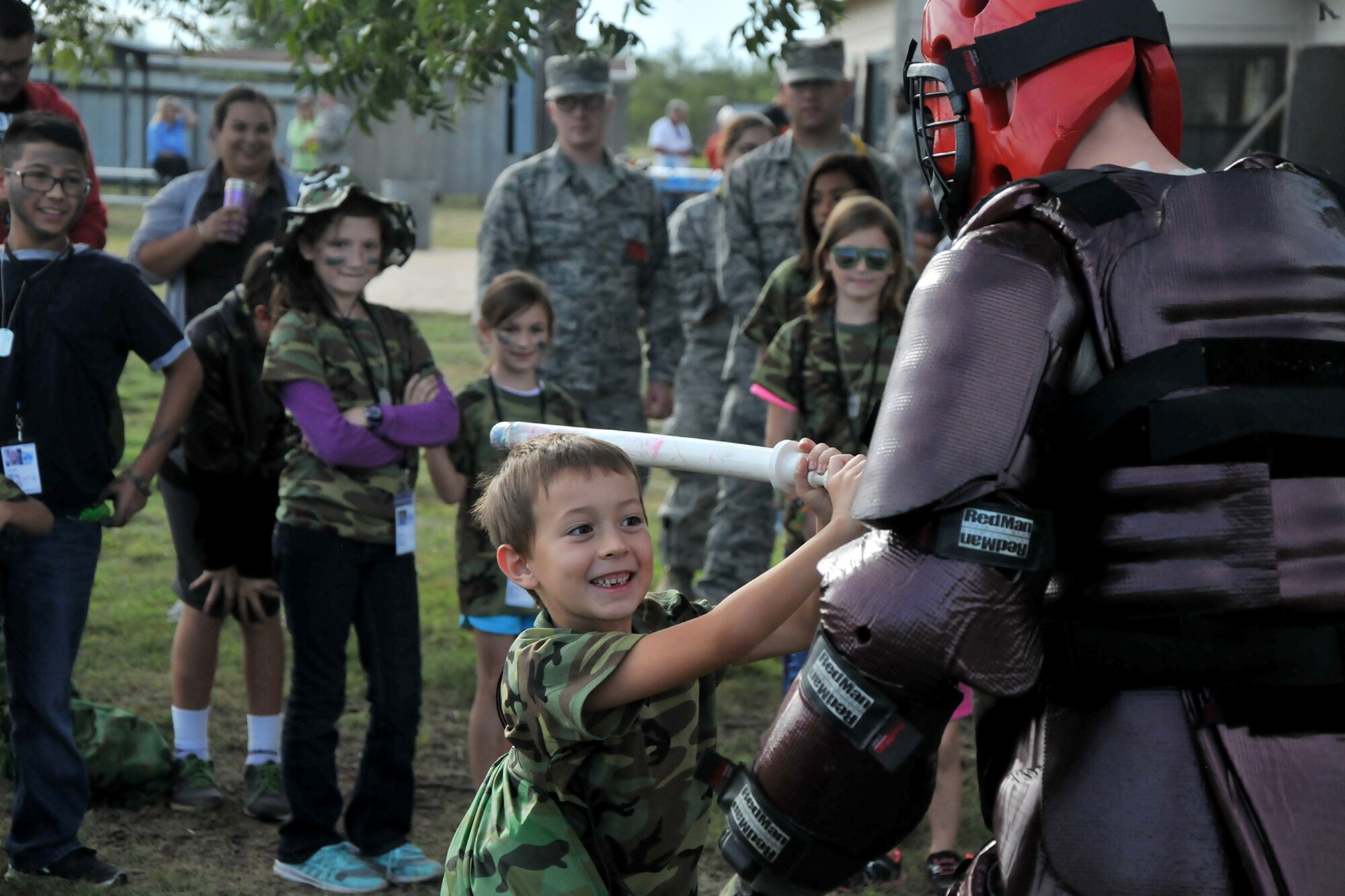 A child swings a dummy baton at a padded Airman during Operation Kids Investigating Deployment Services at the 17th Force Support Squadron on Goodfellow Air Force Base, Texas, Oct. 1, 2016. The 17th Security Forces Squadron gave the children mock pre-deployment training. (U.S. Air Force photo by Airman 1st Class Randall Moose/Released)