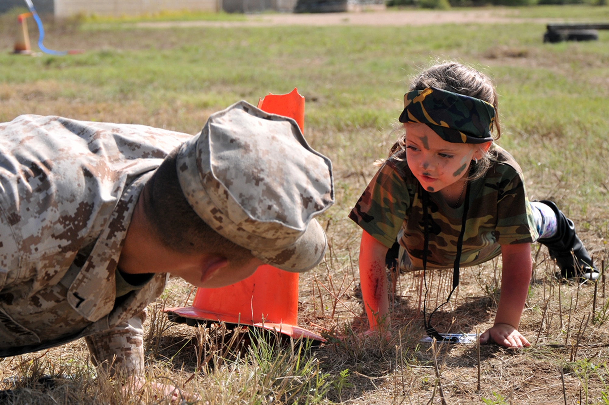 A child performs push-ups with a Marine during Operation Kids Investigating Deployment Services at Camp Sentinel on Goodfellow Air Force Base, Texas, Oct. 1, 2016. Operation KIDS volunteers gave children a perspective on what its like to be on a military deployment. (U.S. Air Force photo by Airman 1st Class Randall Moose/Released)