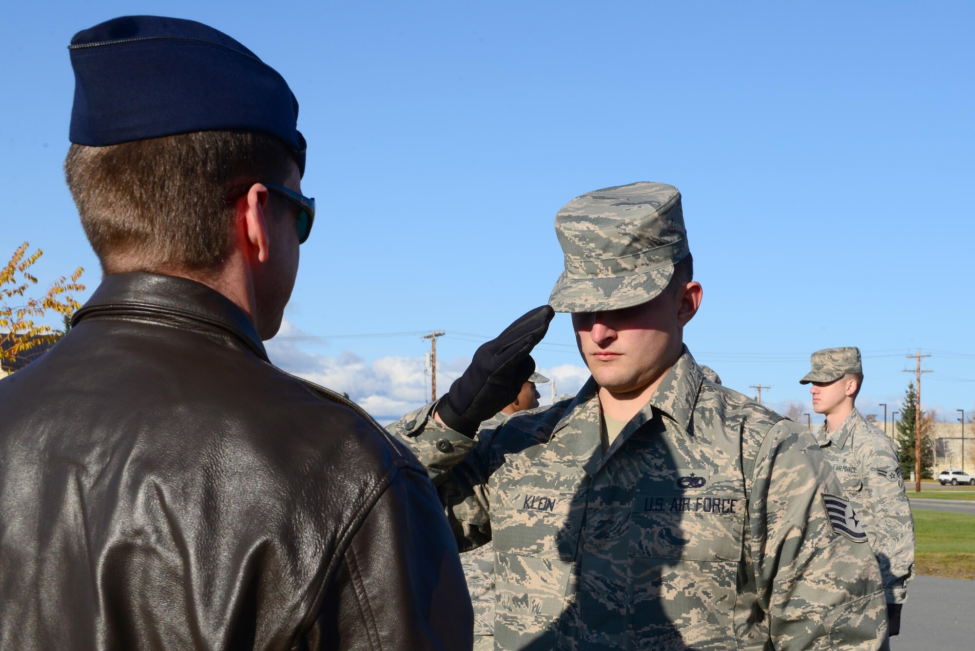 U.S. Air Force Staff Sgt. Christian Klein, a 354th Aircraft Maintenance Squadron avionics craftsman, salutes a flag in the hands of Lt. Col. Matthew Belle, the 354th Operations Support Squadron commander, Sept. 26, 2016, at Eielson Air Force Base, Alaska. Belle participated in the Honor Guard job shadowing event, with Klein demonstrating how to present the flag to a family during a funeral detail. (U.S. Air Force photo by Airman 1st Class Cassandra Whitman)