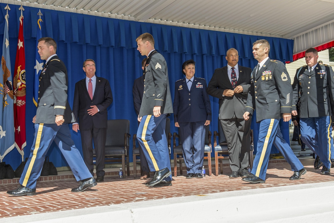 Defense Secretary Ash Carter stands while service members who competed in the Olympics and Paralympics walk across the stage before an awards ceremony for the athletes at the Pentagon, Oct. 3, 2016. DoD photo by Army Sgt. Amber I. Smith
