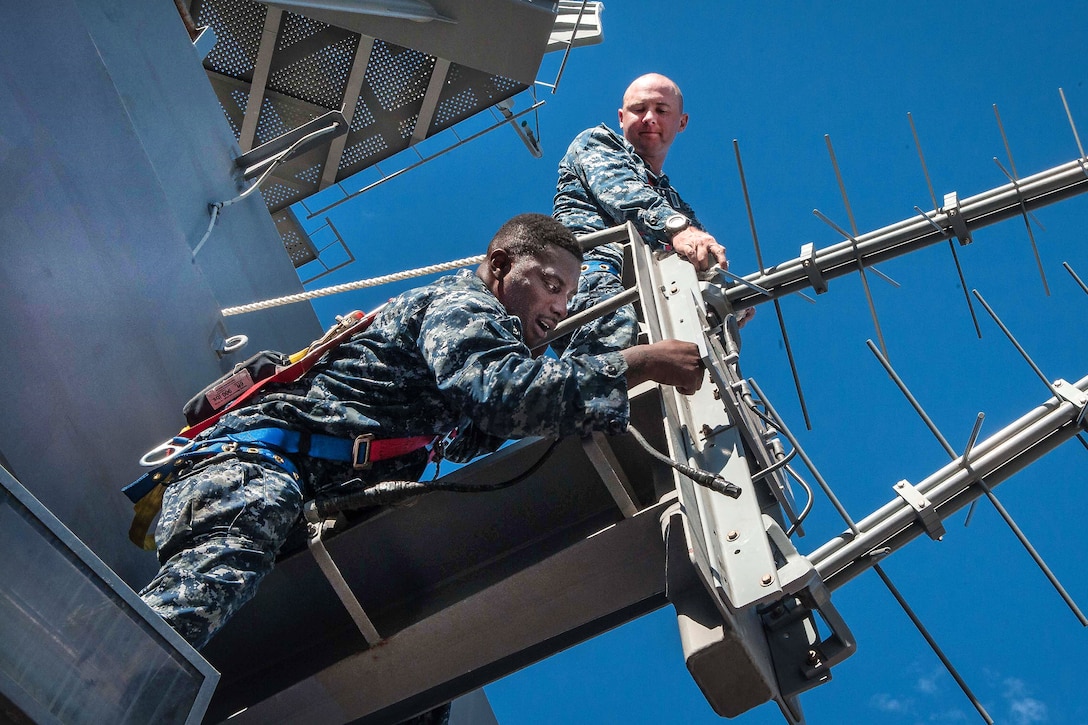 Sailors install an antenna for the SRA-62 combat system on the tower of the aircraft carrier USS Theodore Roosevelt in San Diego, Sept. 29, 2016. The Roosevelt, moored at its homeport in San Diego, is undergoing planned maintenance. Navy photo by Seaman Spencer Roberts