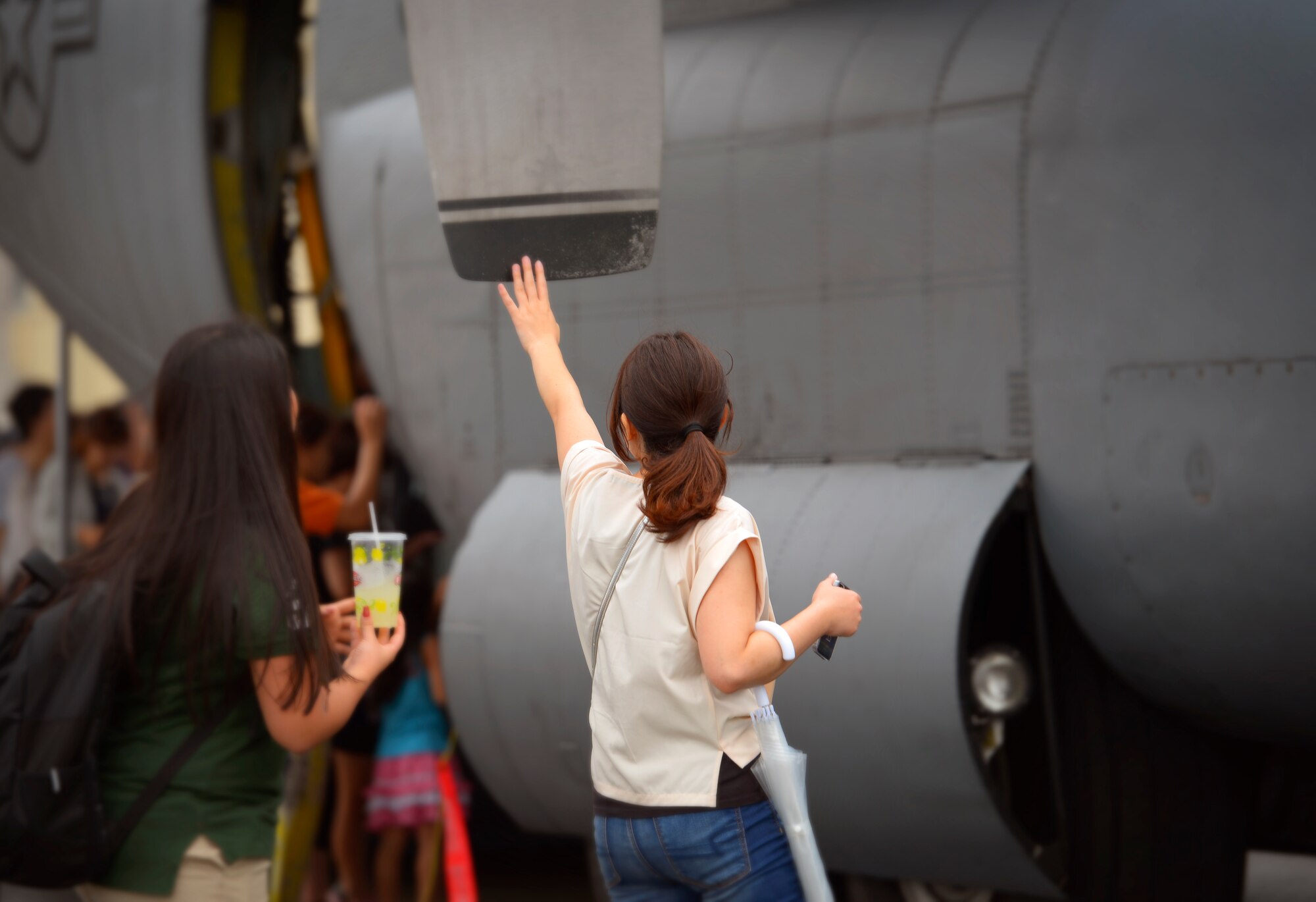 Festivalgoers touch a C-130 H Hercules static display during the 2016 Japanese-American Friendship Festival at Yokota Air Base, Japan, Sept. 17, 2016. The festival gives community members a chance to come onto Yokota to see static aircraft, witness military demonstrations, learn about the capabilities and training done at Yokota and to meet with the US and Japan Self-Defense Force members who work and live here. (U.S. Air Force photo by Airman 1st Class Elizabeth Baker/Released)