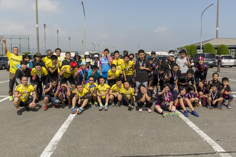 Athletes pose for a group photo after finishing a duathlon during the Special Olympics Nippon Hiroshima at Marine Corps Air Station Iwakuni, Japan, Oct. 2, 2016. Activities held at the Special Olympics included basketball, futsal, tennis, bowling and a duathlon. The Special Olympics instills confidence, inspires a sense of competition and improves health through the transformative power of sports. (U.S. Marine Corps photo by Lance Cpl. Aaron Henson)