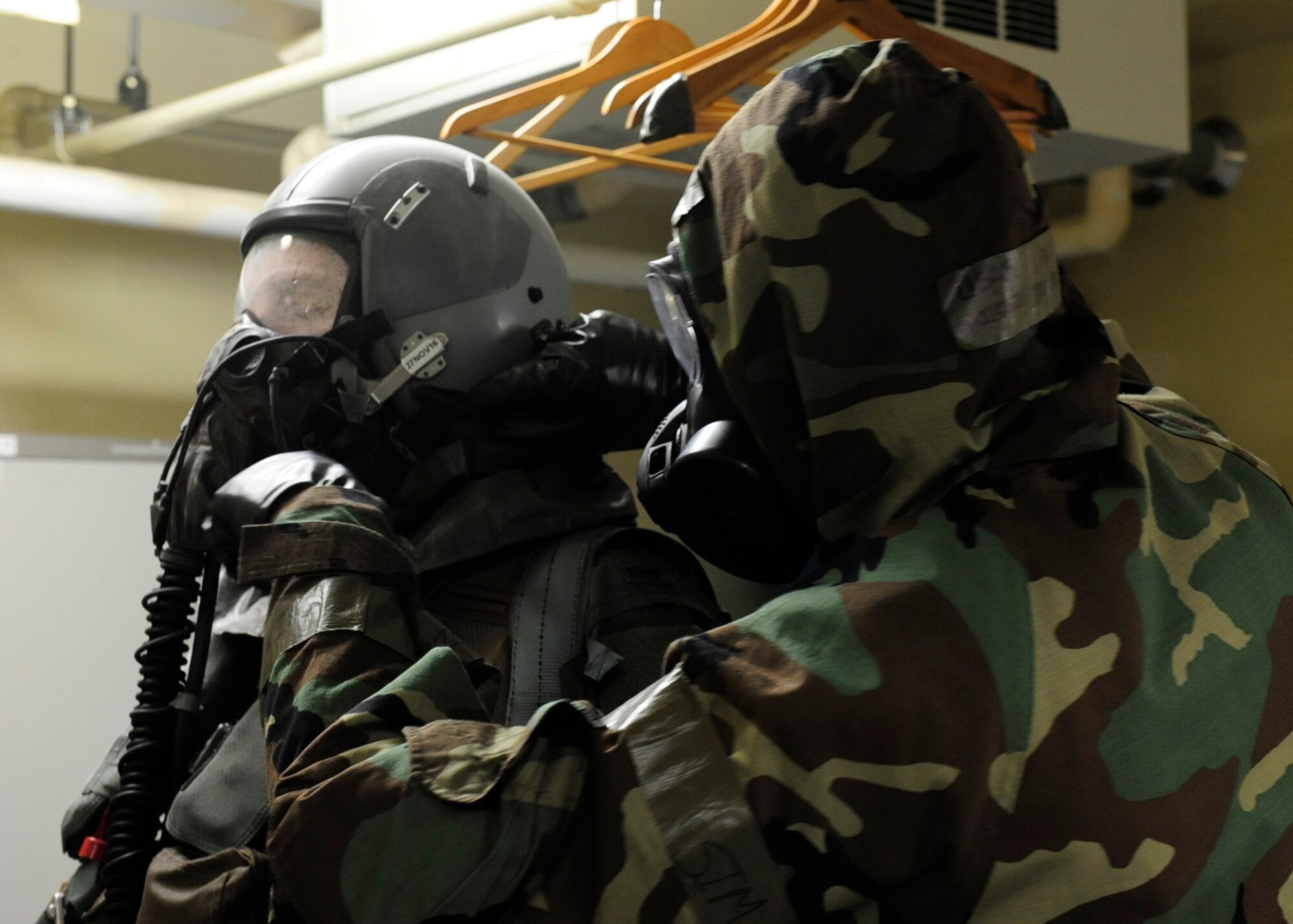 U.S. Air Force Senior Airman Mitchell Bolyard, 8th Operations Support Squadron Aircrew Flight Equipment journeyman, assists an F-16 pilot from the 35th Fighter Squadron decon his individual protective equipment during exercise Beverly Pack 17-1 at Kunsan Air Base, Republic of Korea, Oct. 4, 2016. Aircrew members use a special system, the Aircrew Eye and Respiratory Protection System (AERPS), which ensures they do not contaminate the inside of the aircraft. Equipment includes a motorized breathing system that pumps air into the pilot’s filtered gas mask, a plastic hood, two layers of gloves, plastic booties over their boots, and a clear plastic body bag that ensures full-body coverage of their flight suit. (U.S. Air Force photo/Staff Sgt. Chelsea Browning)