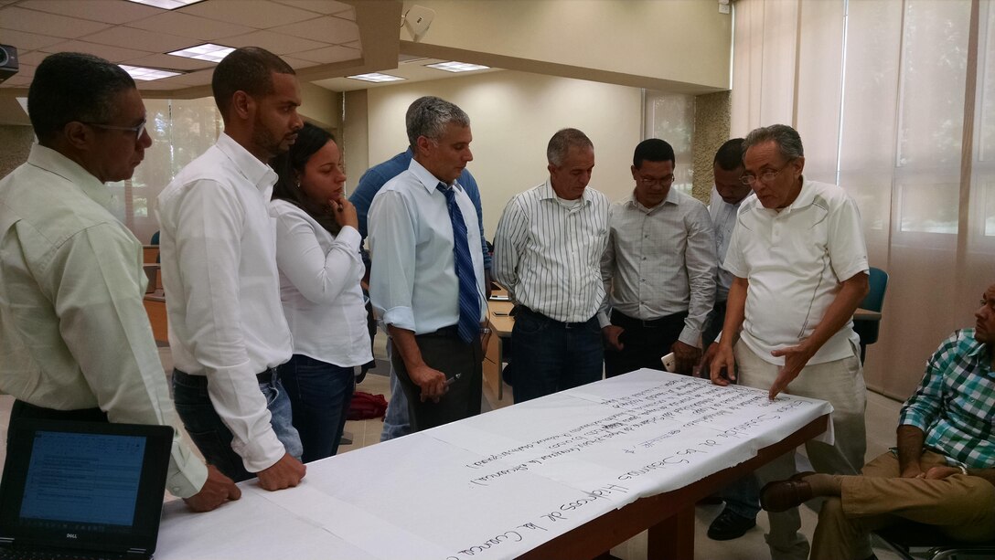 Dominican PMP team members with IWR's Dr. Guillermo Mendoza (center) viewing the prioritized list of the most important problems facing the upper, middle, and lower sub-basins within the Yaque del Norte basin.