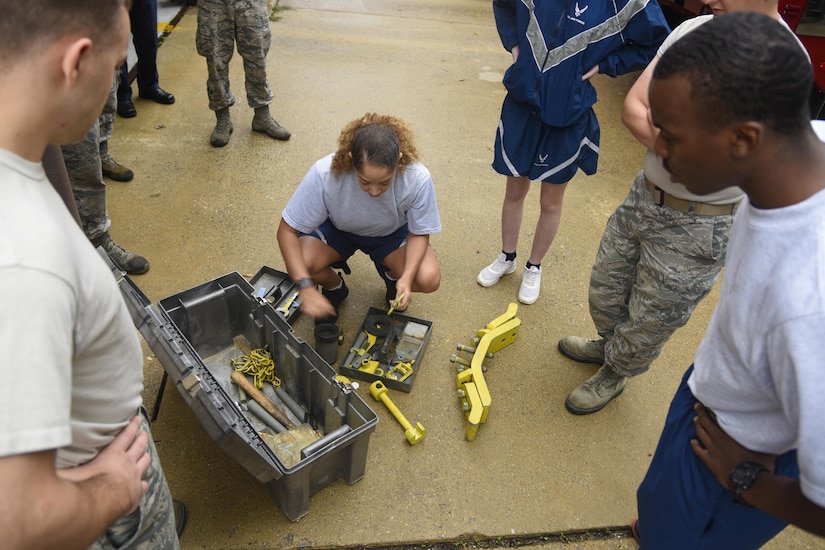 Tech. Sgt. Danielle M. Clark, center, 11th Civil Engineer Squadron section chief of emergency management, is surrounded by 11th Civil Engineer Squadron readiness and emergency managers as she explains what tools they will be using during the HAZMAT training on Joint Base Andrews, Md., Sept. 29, 2016. The purpose of the training is to prepare for a HAZMAT incident. Some of the tools used in the exercise included wrenches, ratchet straps, and metal chains. (U.S. Air Force photo by Airman 1st Class Valentina Lopez)