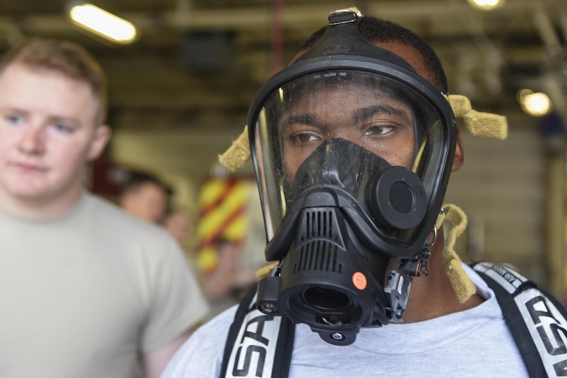 Airman 1st Class Donnie Hamilton, 11th Civil Engineer Squadron readiness and emergency manager, waits for assistance to connect his oxygen mask to an oxygen tank during the hazardous material training on Joint Base Andrews, Md., Sept. 29, 2016. The HAZMAT exercise is designed to teach readiness and emergency managers the procedures to take during a HAZMAT accident that may cause further damage to life, health, properties or the environment. The oxygen mask is designed to keep out breathable toxins that may be present in the handling of hazardous material. (U.S. Air Force photo by Airman 1st Class Valentina Lopez)