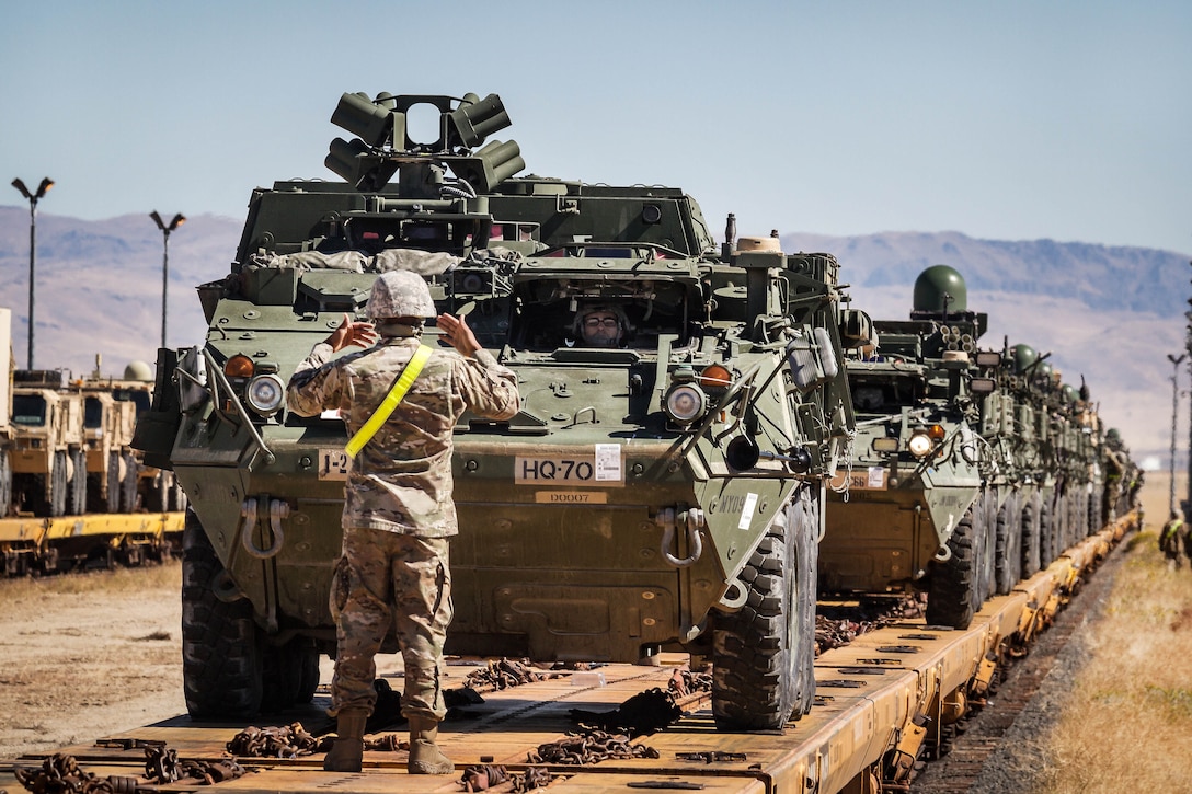 A soldier uses hand signals to guide a Stryker armored vehicle at Orchard Combat Training Center, Idaho, Sept. 27, 2016. Army photo by Capt. Brian Harris