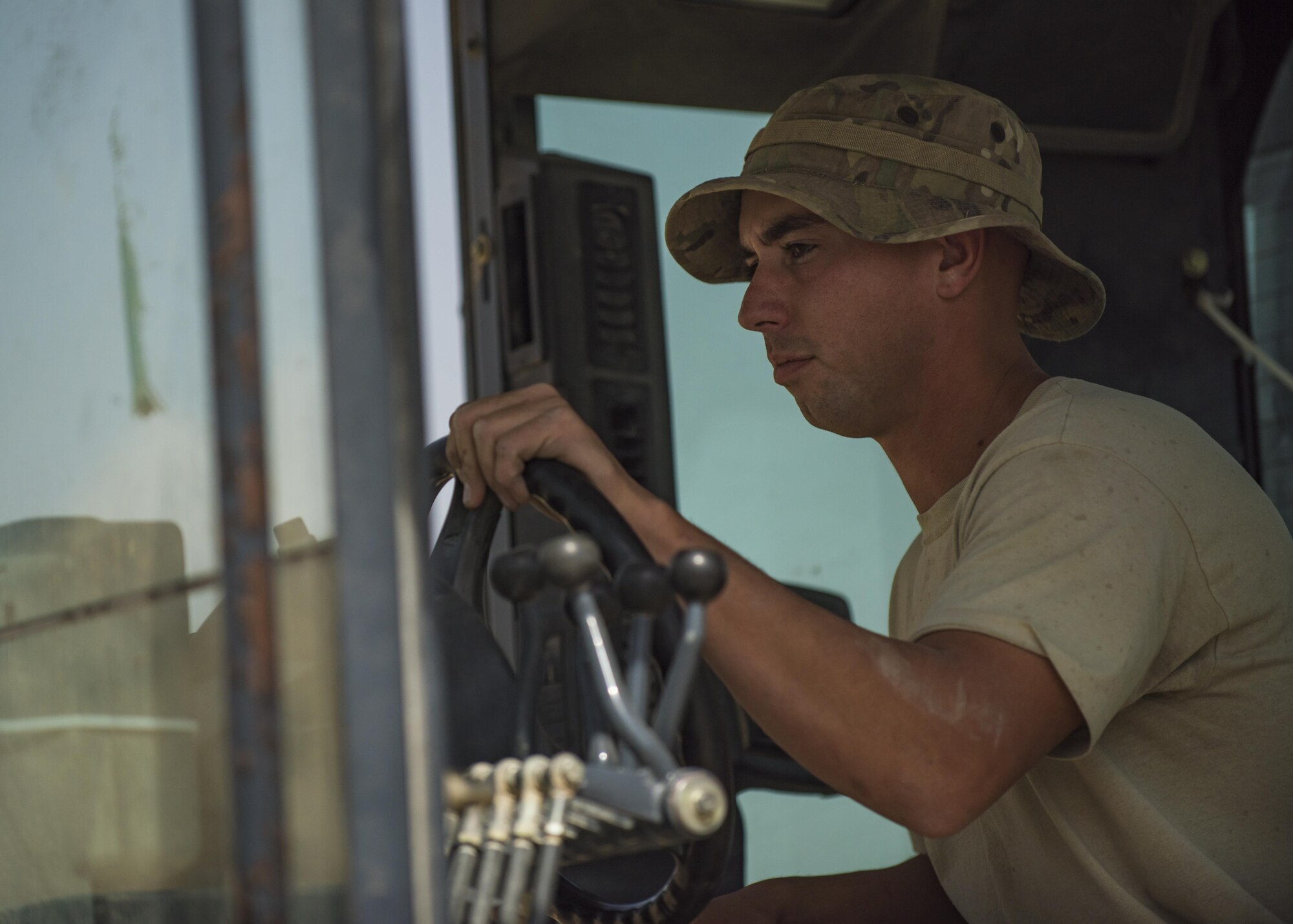 Senior Airman Austin DeDeo, 455th Expeditionary Civil Engineer Squadron pavements and heavy equipment technician, steers a motor grader, Bagram Airfield, Afghanistan, Oct. 4, 2016. Motor graders are used to level gravel in preparation to build roads. (U.S. Air Force photo by Senior Airman Justyn M. Freeman)