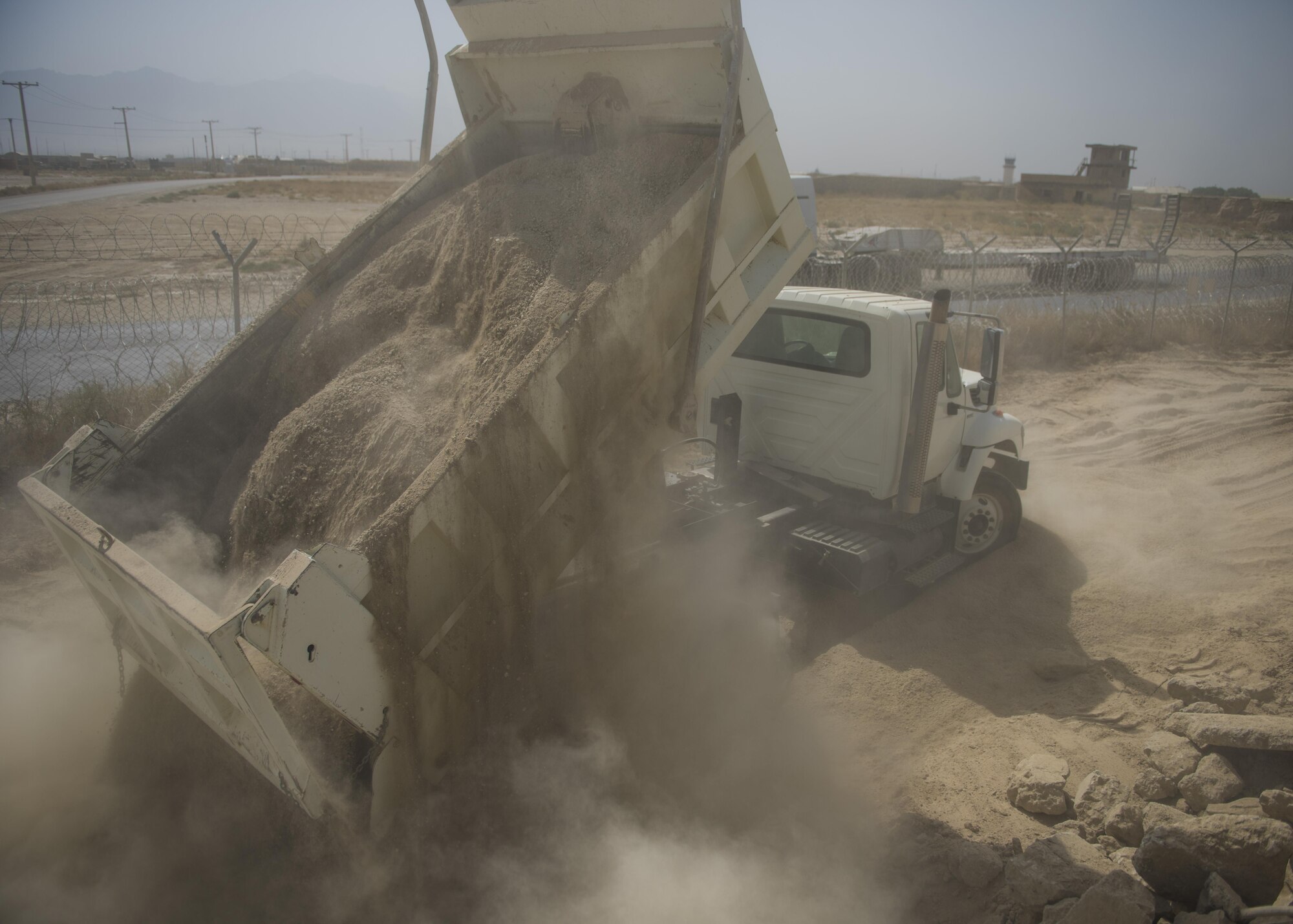 The 455th Expeditionary Civil Engineer Squadron “Dirt Boys”, dumped dirt and gravel onto the ground, Bagram Airfield, Afghanistan, Oct. 4, 2016. The gravel is being transported and dumped in preparation to build a new road. Once the foundation is laid and leveled, ECES will complete the process by adding concrete. (U.S. Air Force photo by Senior Airman Justyn M. Freeman)