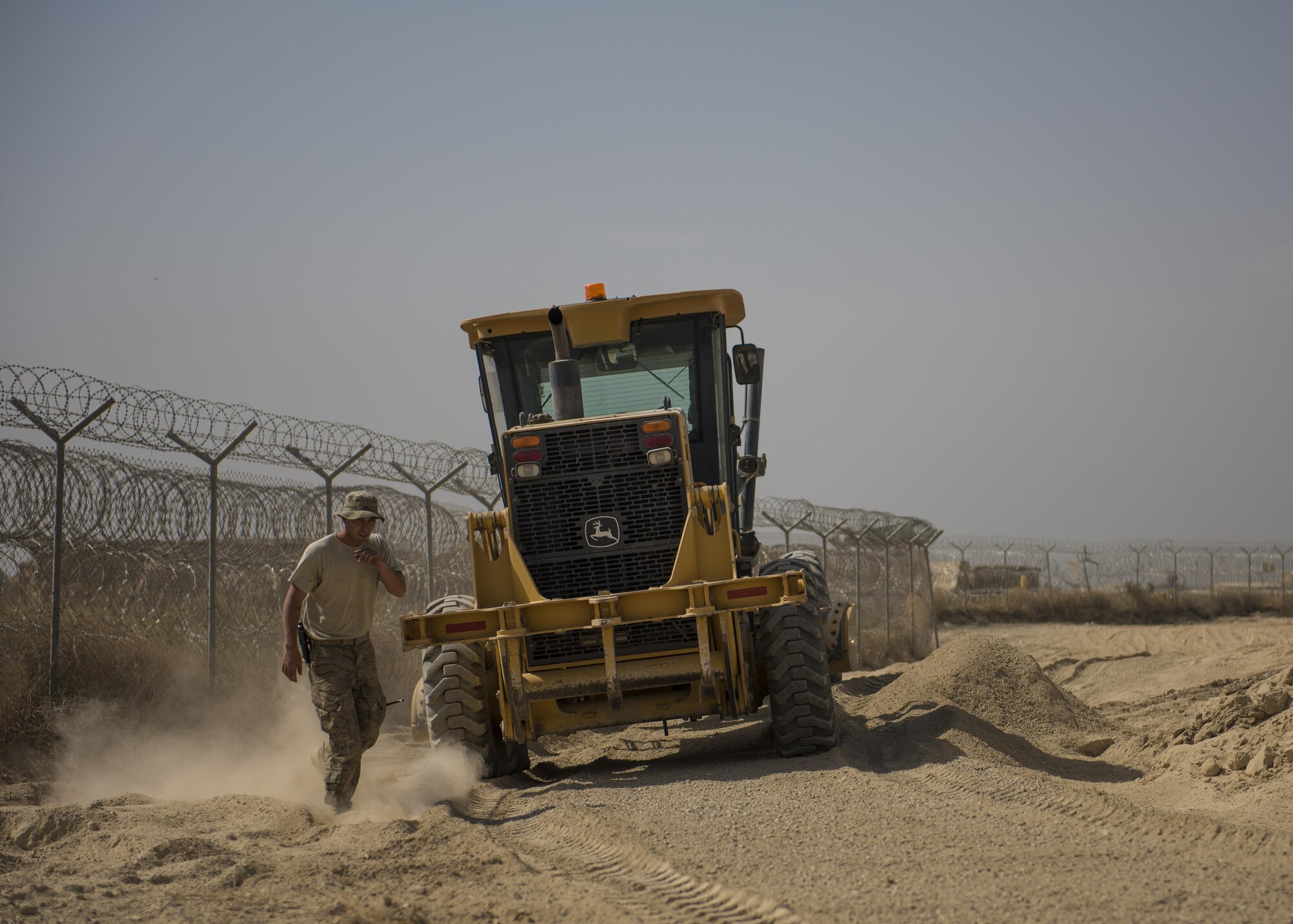 Senior Airman Austin DeDeo, 455th Expeditionary Civil Engineer Squadron pavements and heavy equipment technician, checks his work after leveling gravel, Bagram Airfield, Afghanistan, Oct. 4, 2016. The ECES “Dirt Boys”, as they are known, laid down gravel to start the foundation for a new road. The road, which will provide a pathway for mine-resistant ambush-protected (MRAP) vehicles, will be built around the fence line of the airfield and utilized by security forces as a means to secure the flightline. (U.S. Air Force photo by Senior Airman Justyn M. Freeman)