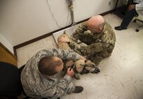 (From left) Staff Sgt. Sean King, 319th Security Forces Squadron military working dog handler, holds MWD Arco, while Staff Sgt. Oliver Brunhoeber, 5th Medical Group NCO in charge of the base veterinarian clinic, checks the dog’s heart rate during a vet visit at Minot Air Force Base, N.D., Sept. 28, 2016. The base veterinarians provide healthcare to MWDs as well as active duty members’ pets. (U.S. Air Force photo/Airman 1st Class Christian Sullivan)