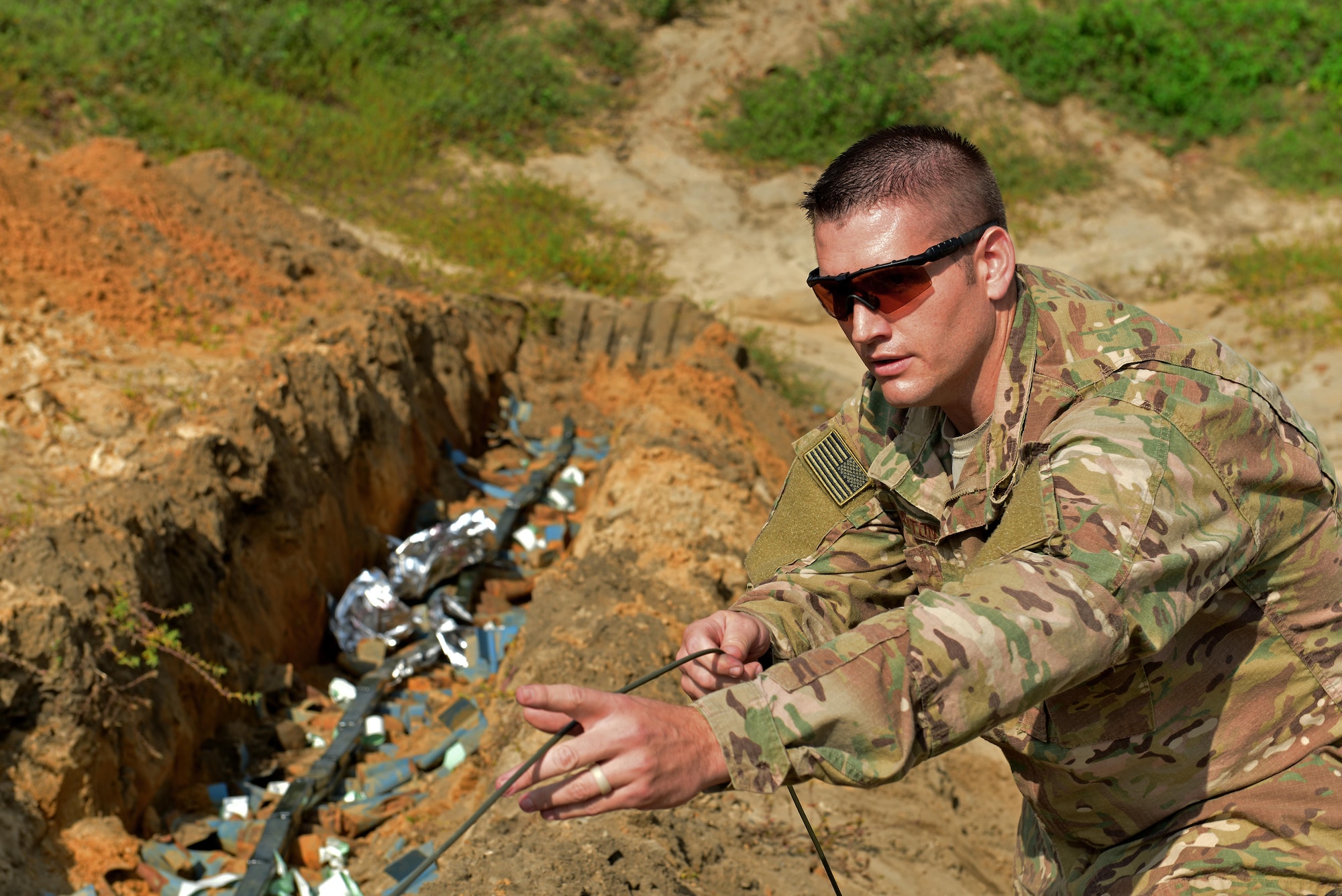 U.S. Air Force Senior Airman Wesley Clayton, 20th Civil Engineer Squadron explosive ordnance disposal journeyman, unrolls detonation cord at Poinsett Electronic Combat Range, Wedgefield, S.C., Sept. 29, 2016. During the semi-annual clearing, EOD Airmen destroyed approximately 160 bomb dummy units to help maintain the range. (U.S. Air Force photo by Airman 1st Class Destinee Sweeney)