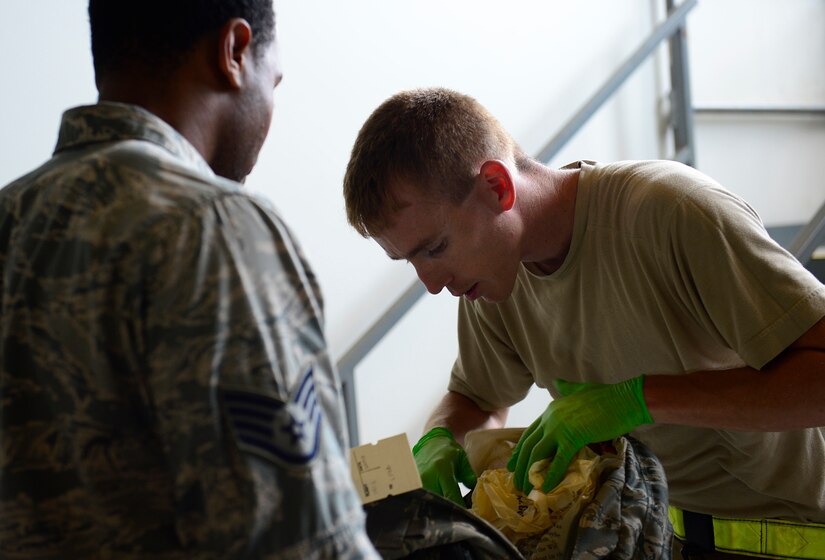 U.S. Air Force Staff Sgt. Aaron Hauson, 733rd Logistics Readiness Squadron vehicle maintenance technician, inspects an Airman’s bag during an operational readiness exercise at Joint Base Langley-Eustis, Va., Sept. 28, 2016. The 1st Fighter Wing and 192nd Fighter Wing tested the Wings’ readiness, if faced with short-notice orders to deploy, a disaster, imminent terrorist or enemy threat. (U.S. Air Force photo by Airman 1st Class Kaylee Dubois)
