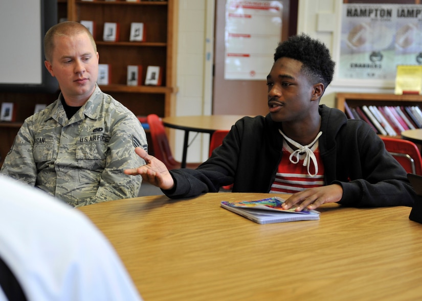 U.S. Air Force Senior Airman Seth Morgan, 1st Operations Support Squadron airfield systems technician, left, listens to Gregory Blythe, Hampton High School 10th grade student, during a Real Access to Diversity team mentor session at Hampton High School in Hampton, Va., Sept. 30, 2016.  The RAD team is comprised of Airmen who mentor students in science, technology, engineering, and math courses on the practical application of STEM principles. (U.S. Air Force photo by Tech. Sgt. Katie Gar Ward)