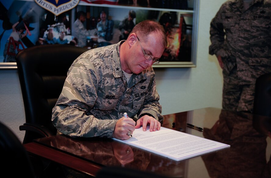 Brigadier Gen. Richard G. Moore, Jr., 86th Airlift Wing commander, signs a domestic violence awareness month proclamation at Ramstein Air Base, Germany, Oct. 3, 2016. The proclamation states that domestic violence is a crime that has no place in the Air Force, and that October is domestic violence awareness month. (U.S. Air Force photo by Airman 1st Class Savannah L. Waters)
