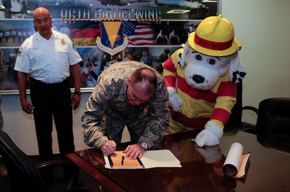 Brigadier Gen. Richard G. Moore, Jr., 86th Airlift Wing commander, signs a fire prevention week proclamation at Ramstein Air Base, Germany, Oct. 3, 2016. Fire prevention week educates the public to take precautions to prevent potentially harmful fires. (U.S. Air Force photo by Airman 1st Class Savannah L. Waters)