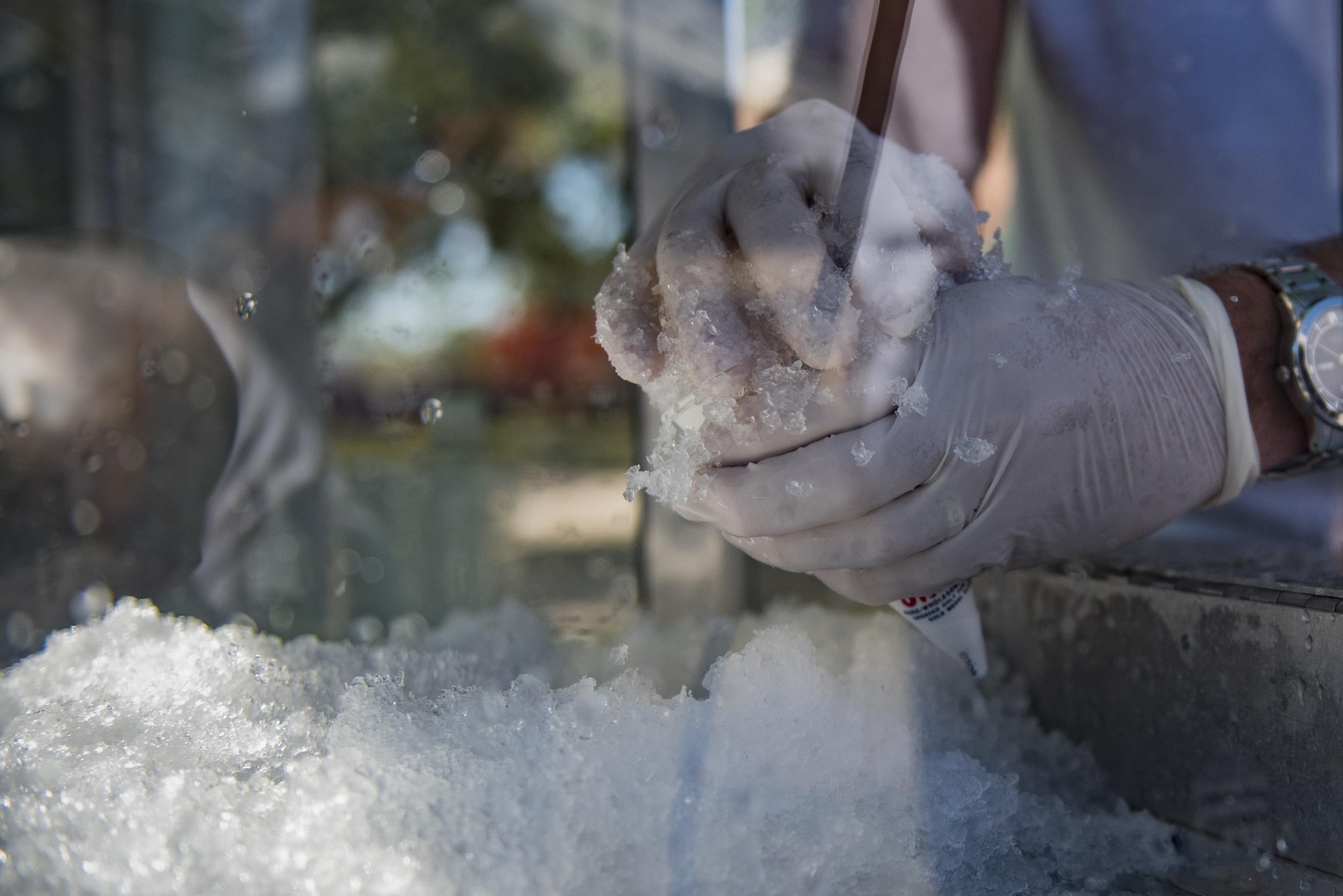 A volunteer compresses shaved ice into a snowcone during Comprehensive Airman Fitness day, Sept. 30, 2016, at Moody Air Force Base, Ga. The Moody’s Chiefs’ group prepared an assortment of snacks and refreshments including hotdogs, bratwursts and chips for Airmen. (U.S. Air Force photo by Airman 1st Class Daniel Snider)  
