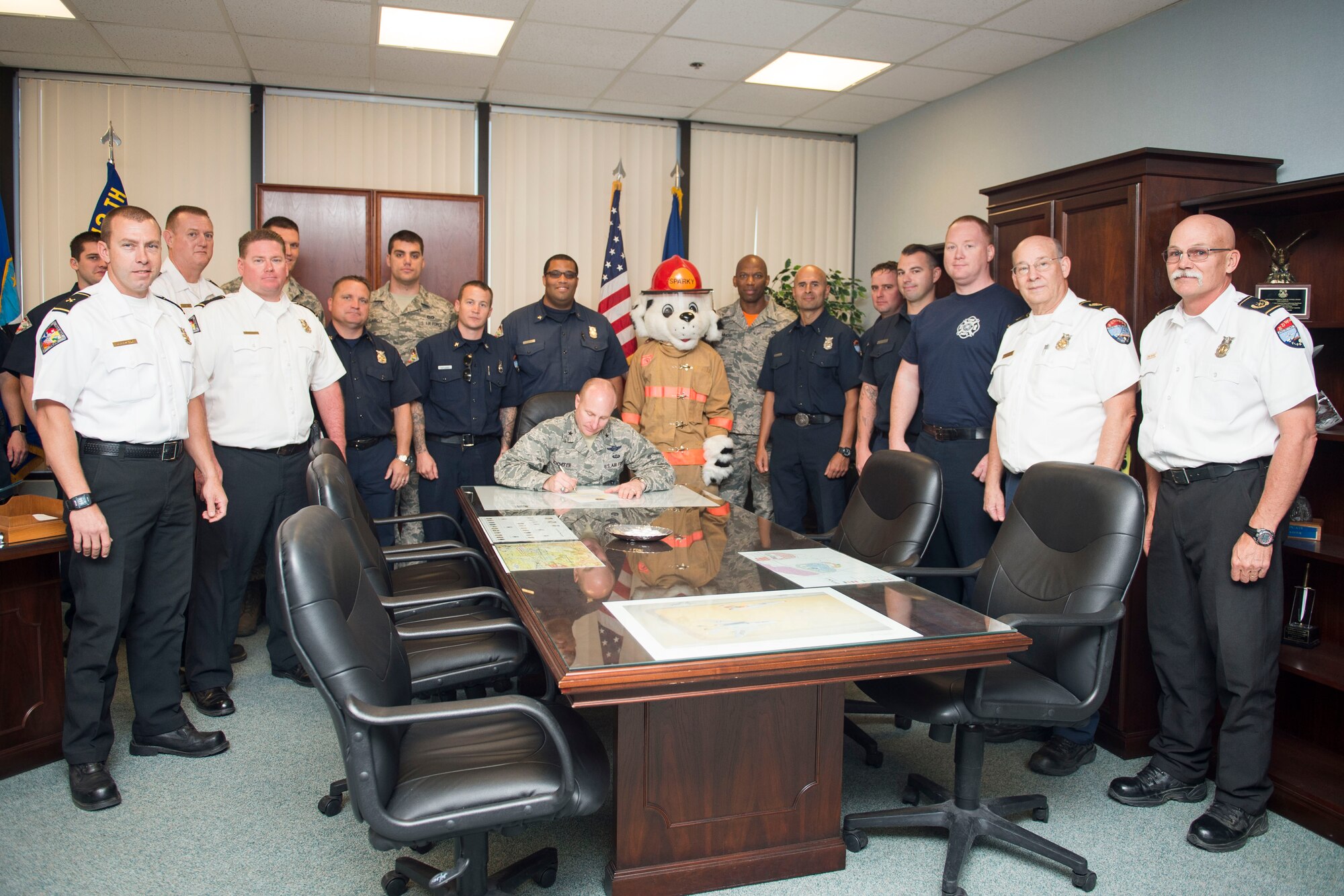 Brig. Gen. Carl Schaefer, 412th Test Wing commander, signs the Fire Prevention Week 2016 Proclamation in his office Sept. 16 along with members of the Edwards AFB Fire Department and Sparky the Fire Dog. (U.S. Air Force photo by Ethan Wagner)