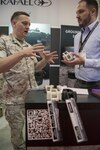 160928-N-IL267-003 QUANTICO, Virginia (Sept. 28, 2016) Marine Sgt. Stephen Cook, a legal service specialist with Headquarters Marine Corps, Judge Advocate Division, and amateur hobbyist 3-D printer, and Jonathan Hopkins, a member of the Additive Manufacturing Tiger Team and employee of Naval Surface Warfare Center, Carderock Division, discuss 3-D printed parts at the Modern Day Marine Expo at Marine Corps Base Quantico, Va. Naval Sea Systems Command, Naval Aviation Systems Command, Marine Corps Systems Command, the Marine Corps Warfighting Laboratory, and Marine Corps Headquarters, Installations and Logistics Department collaborated on an additive manufacturing parts demonstration at the expo. (U.S. Navy photo by Dustin Q. Diaz/released)