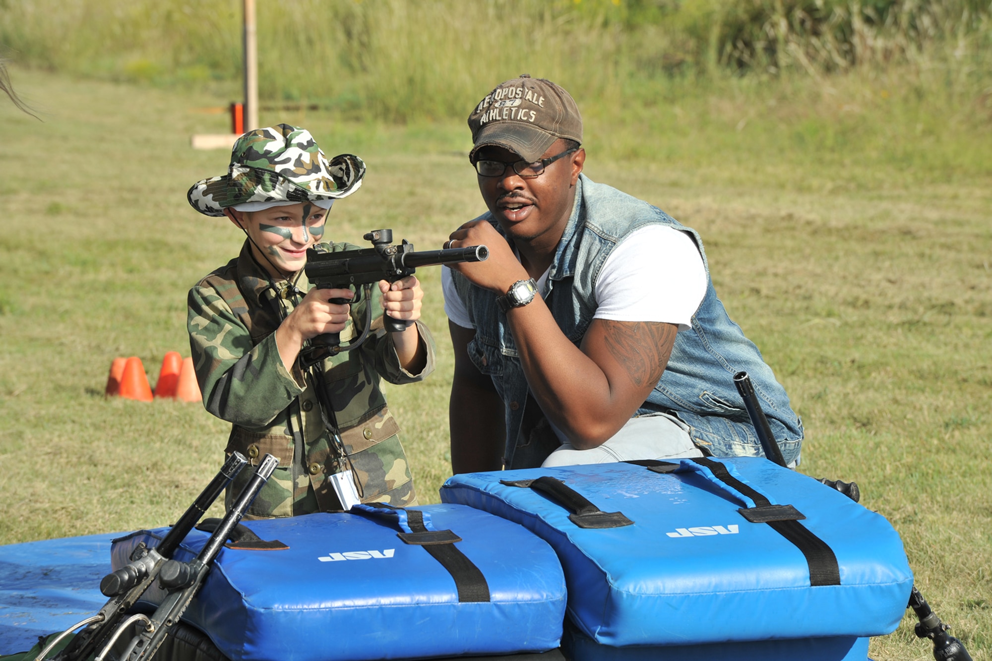 U.S. Air Force Airman 1st Class Richard Broadnax III, 17th Security Forces Squadron entry controller, assists a child with entry control techniques during Operation Kids Investigating Deployment Services at the 17th Force Support Squadron Lodge, Goodfellow Air Force Base, Texas, Oct. 1, 2016. The 17th Security Forces Squadron trained the youths for their deployment. (U.S. Air Force photo by Staff Sgt. Laura R. McFarlane/Released)