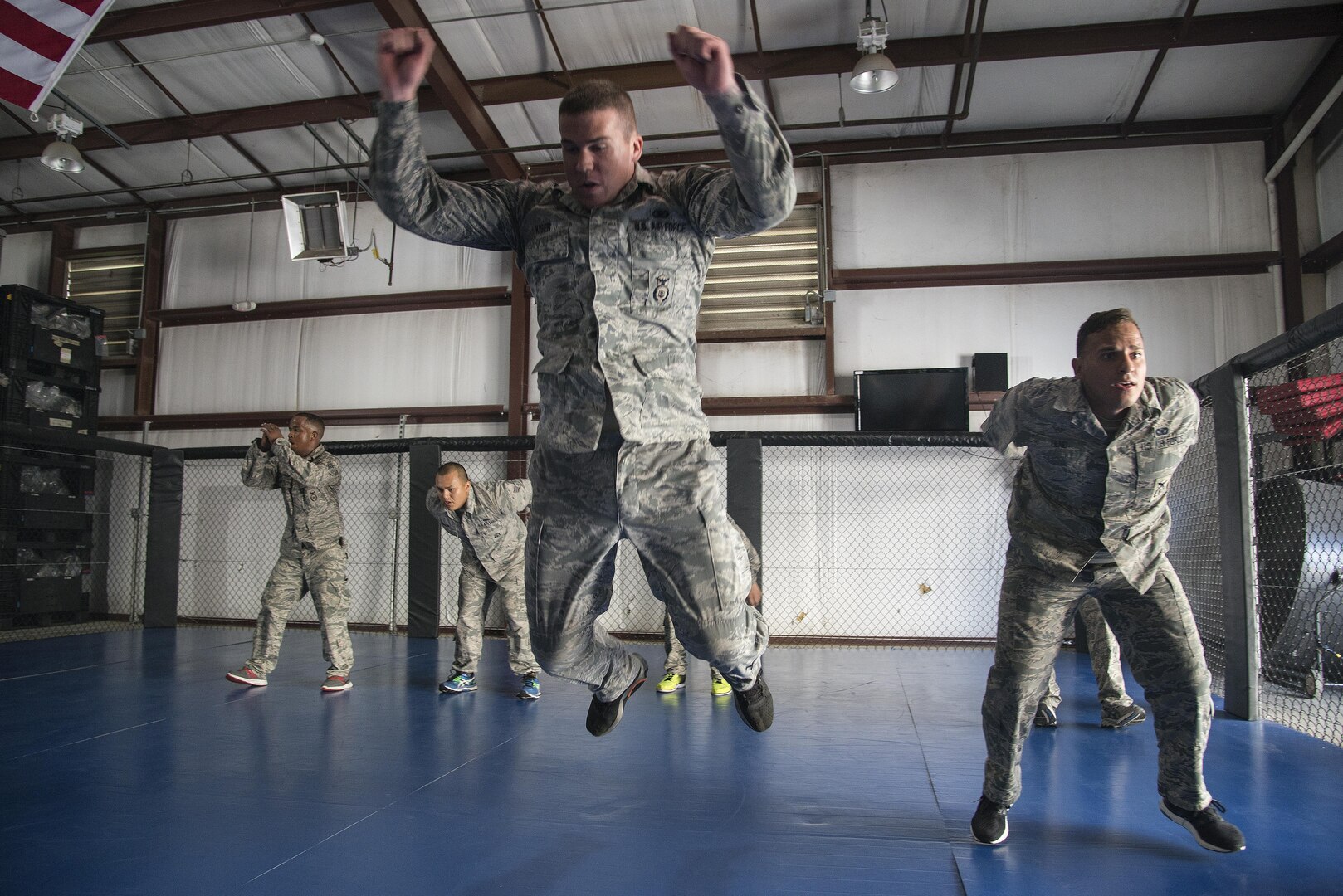 Staff Sgt. Neal Kiser and Senior Airman Andrew Deno, 902nd Security Forces Squadron, jump as a part of physical exercise during compatives training Sept. 14 at Joint Base San Antonio-Randolph. Kimura and Americana submission holds are often seen in mixed martial arts matches, but now they’re also commonplace in Hangar 52 at Joint Base San Antonio-Randolph.
