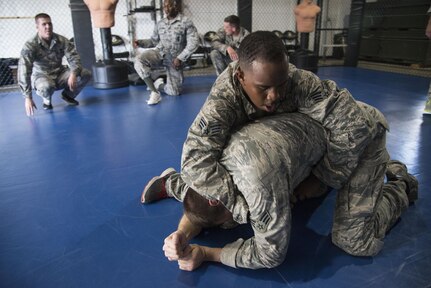 Senior Airman James William, 902nd Security Forces Squadron, subdues Senior Airman Jonathan Bridger during combatives training Sept. 14 at Joint Base San Antonio-Randolph. Kimura and Americana submission holds are often seen in mixed martial arts matches, but now they’re also commonplace in Hangar 52 at Joint Base San Antonio-Randolph.